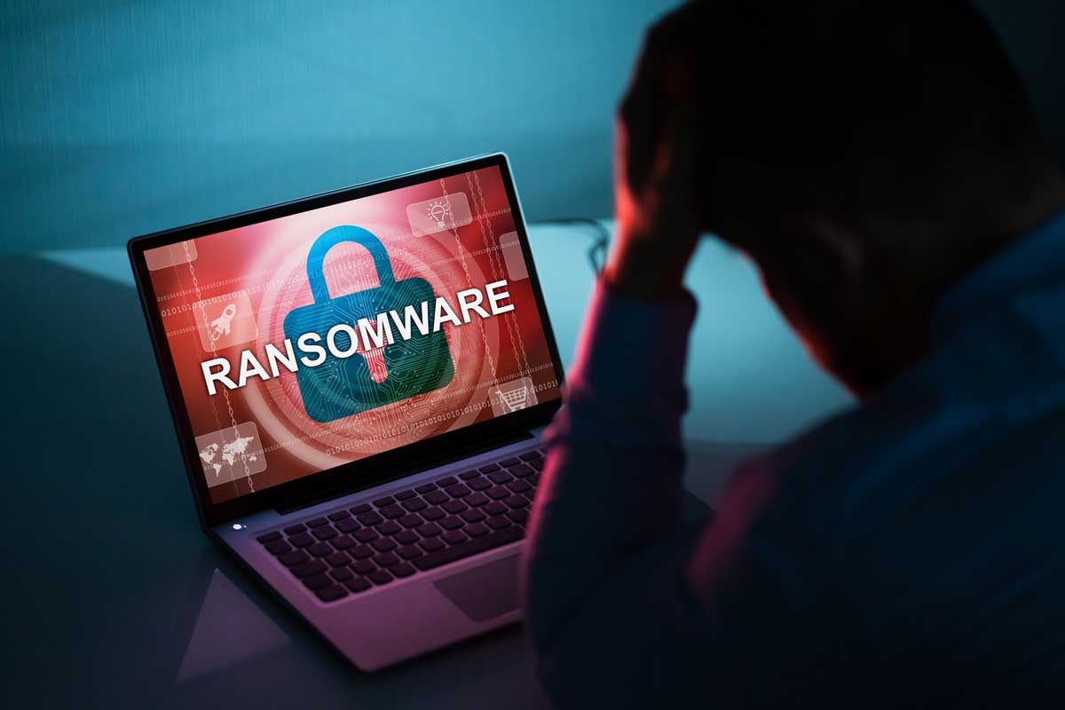 Worried Businessman Looking At Laptop With Ransomware Word On The Screen